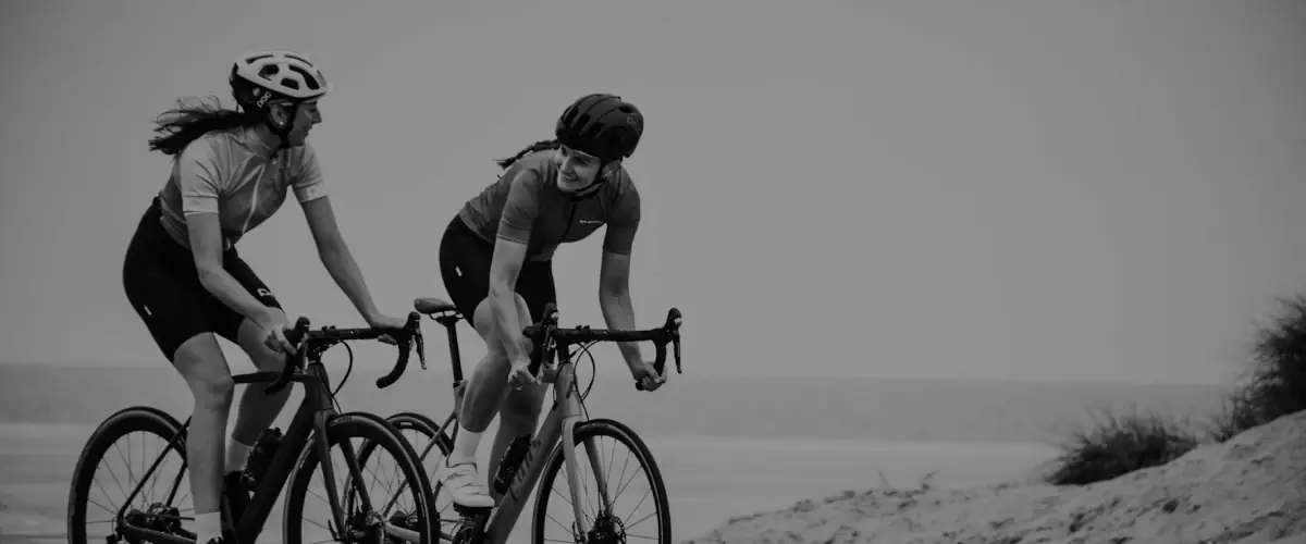 Two cyclists riding by the coast